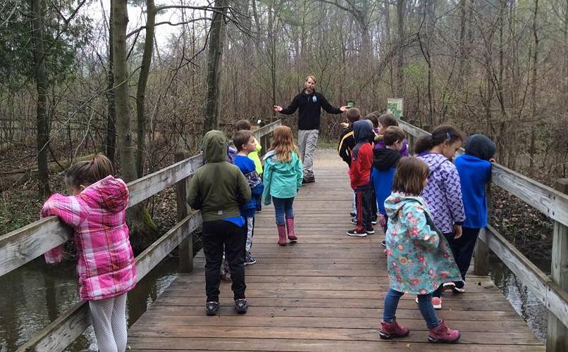 Photo of Students celebrating Earth Day on a bridge at the Stoney Creek Metropark